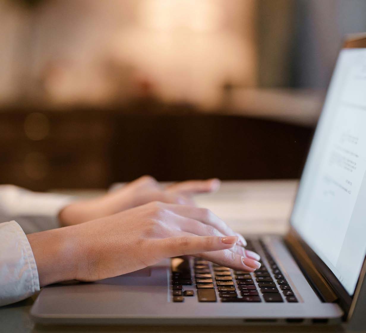 Hände auf der Tastatur eines Laptops